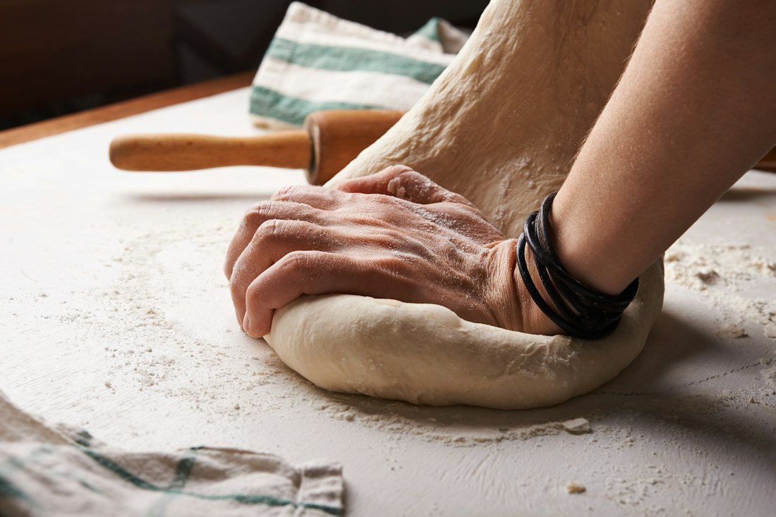 Hands lifting a fresh croissant across the counter